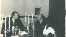 Douglas Cochrane (left) with Pablo Neruda talk over a dinner table